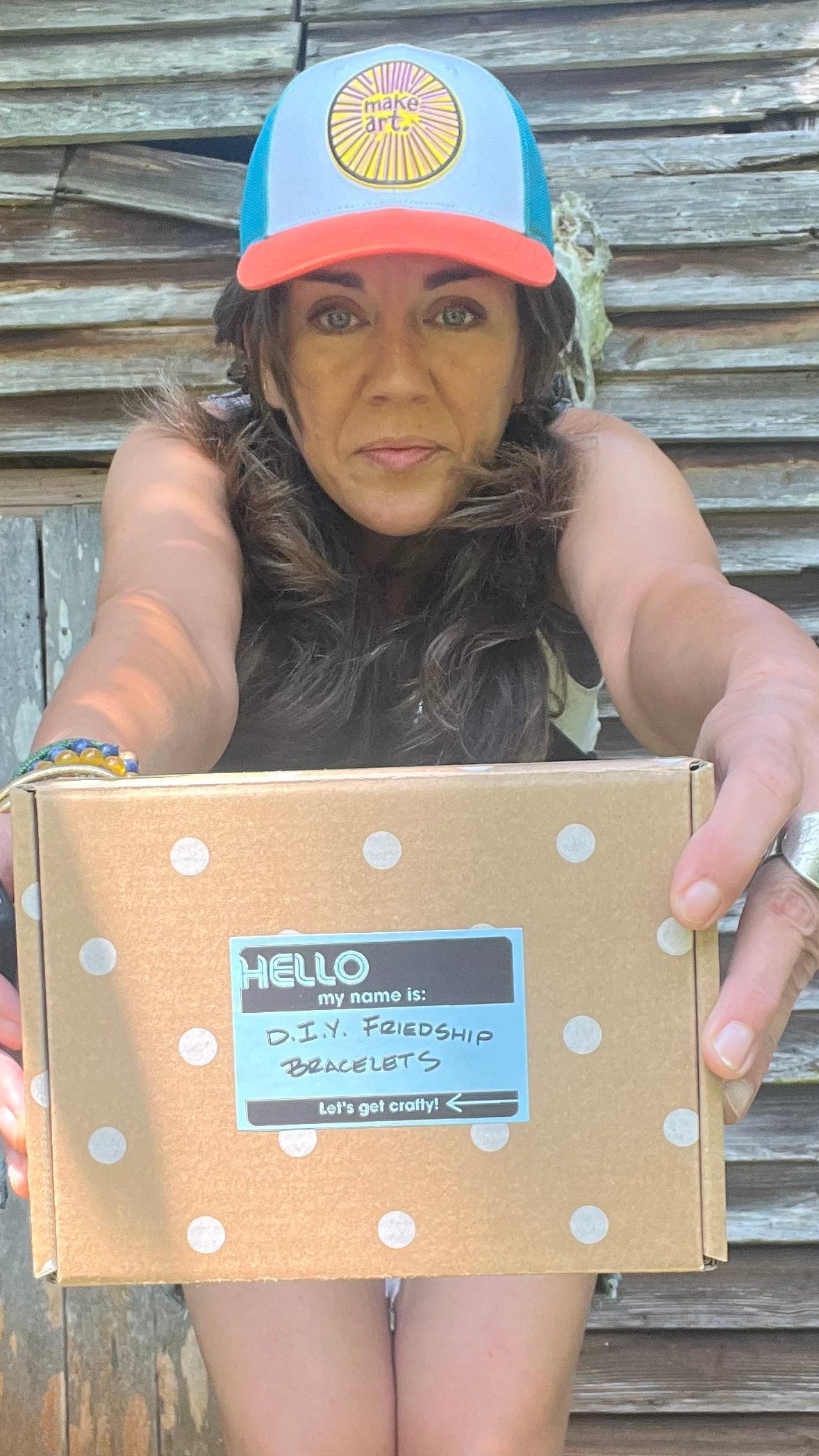 Artist bmakesthings holding her very first DIY craft kit against a weathered rustic barn